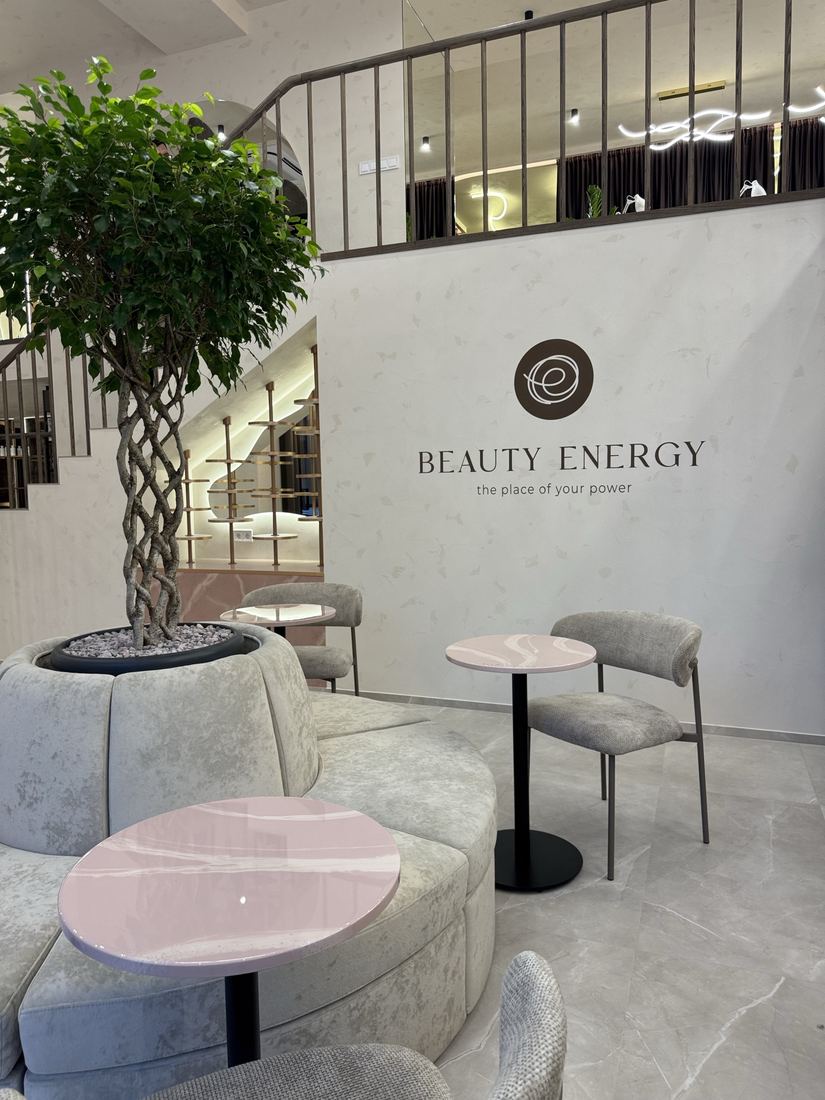 Лаунж-зона салону Beauty Energy з логотипом на стіні